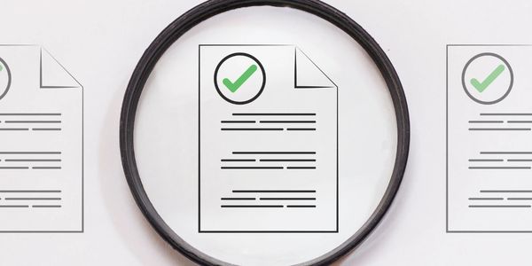 Magnifying glass highlighting a document with a green checkmark.