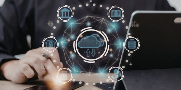 Person using a smartphone and tablet with cloud computing icons overlay.