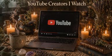 Laptop showing YouTube on a cozy, candle-lit table.