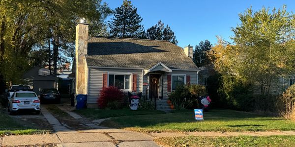 Cozy suburban house with autumn decorations and clear blue sky.