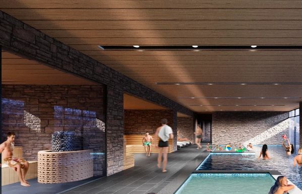 Indoor pool area with people relaxing and swimming in a modern spa-like setting.