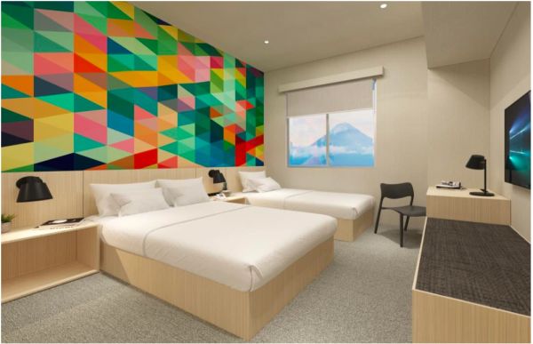 Modern hotel room with two beds and colorful geometric wall art.