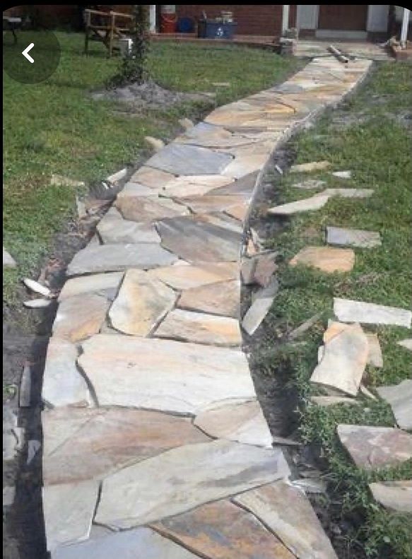 A stone pathway under construction in a garden.