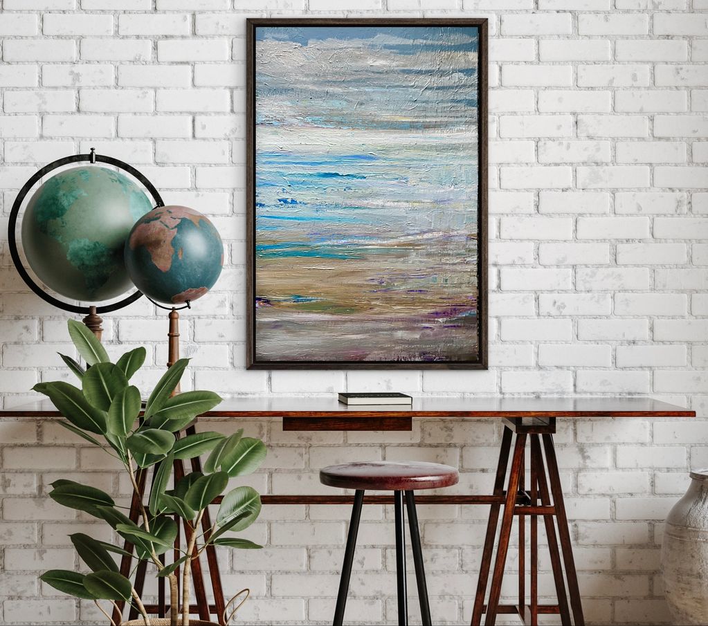 Modern workspace with globes, plant, and abstract painting on white brick wall.