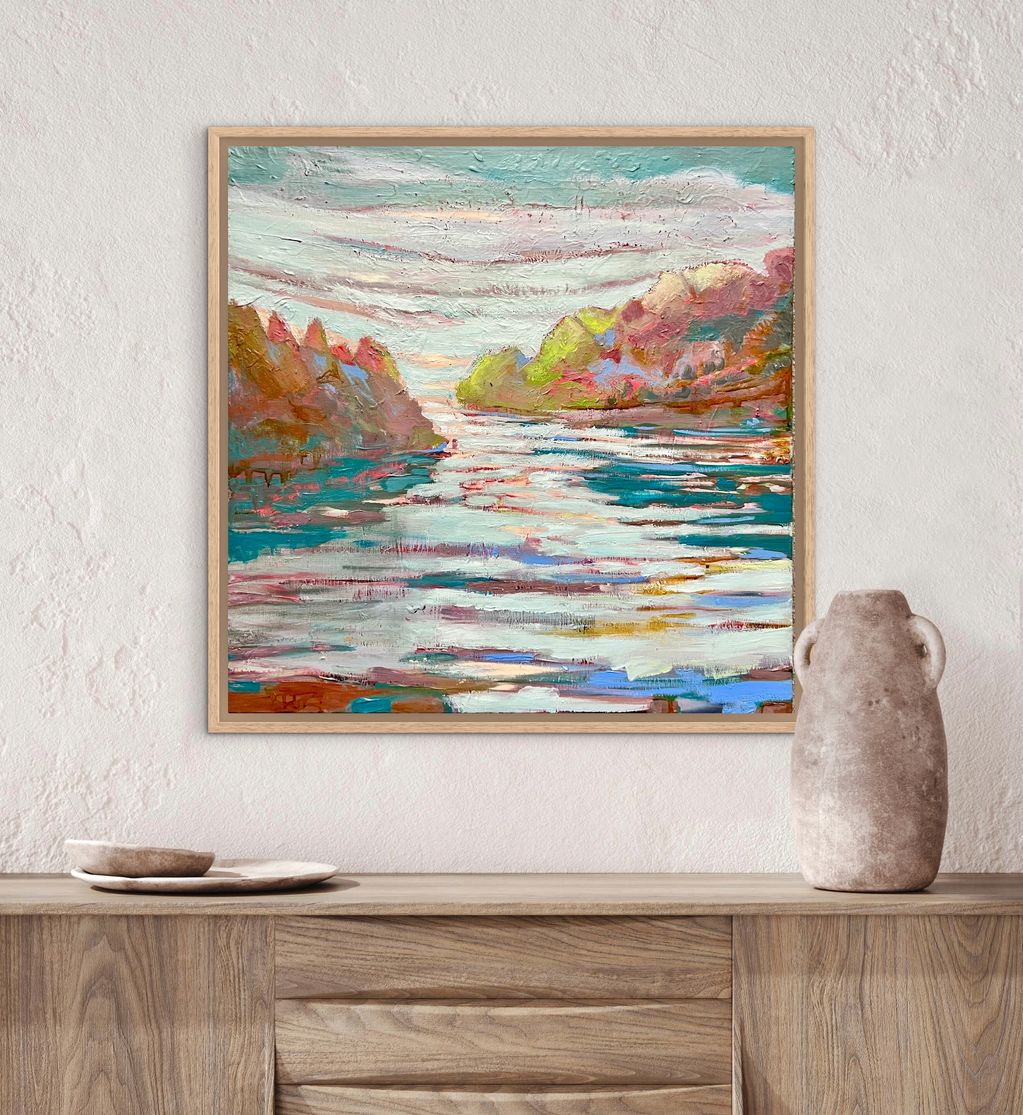 Colorful abstract landscape painting above a wooden cabinet with pottery.