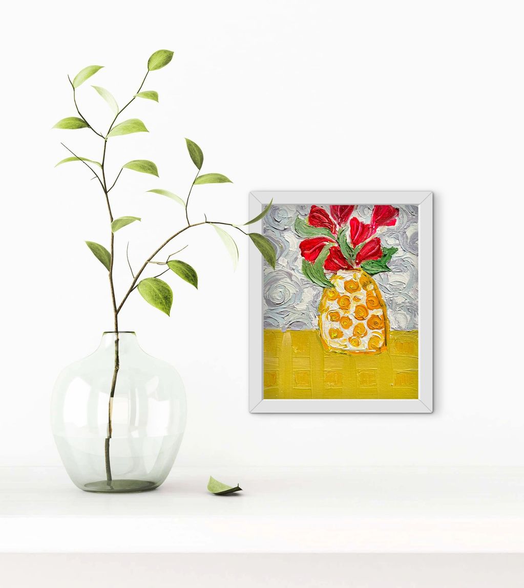 Minimalist decor with a glass vase and a colorful framed painting.