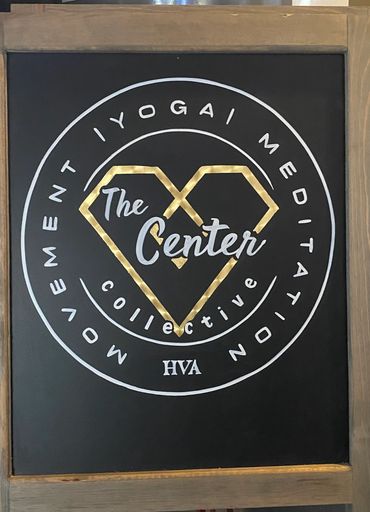Gold leaf heart on The Center Yoga logo.