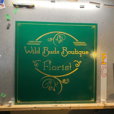 Gold leaf sign of the logo for Wild Buds Boutique & Florist.