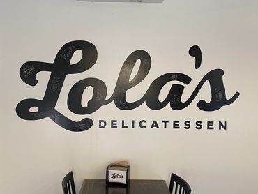 Large wall painting of logo for Lola's Delicatessen.