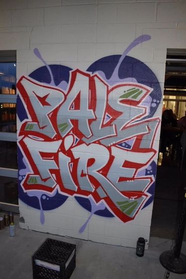 Street art style mural on a brick wall at Pale Fire Brewing.