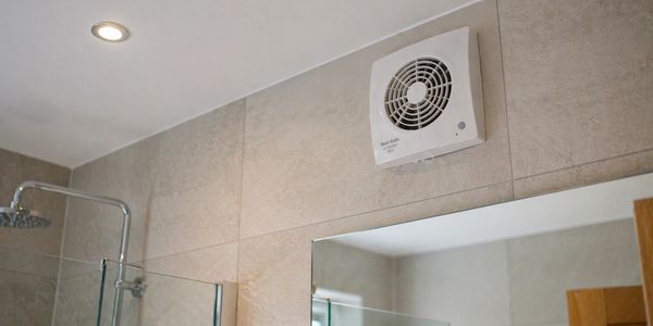 Bathroom ventilation fan installed on tiled wall.