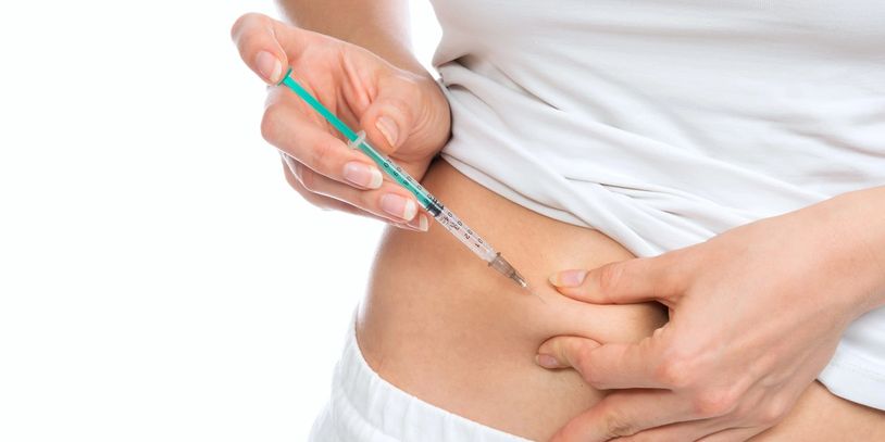 Person injecting insulin into the abdomen.