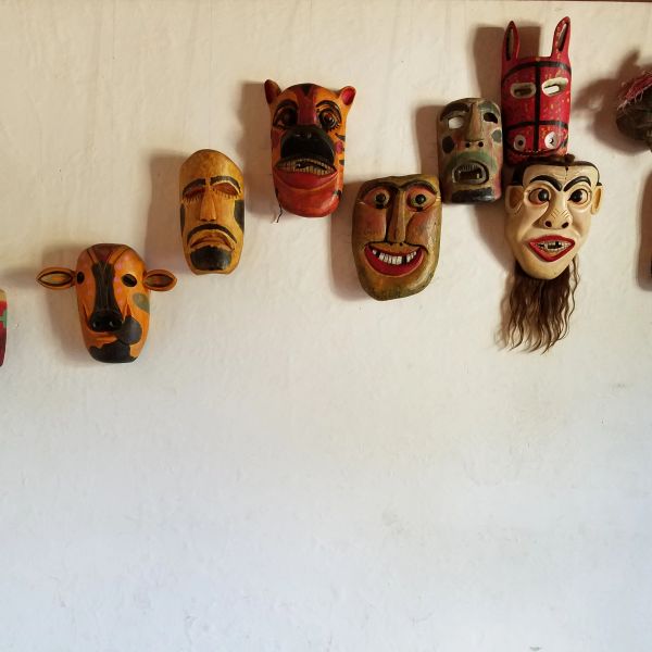Máscaras coloridas colgadas en una pared blanca.