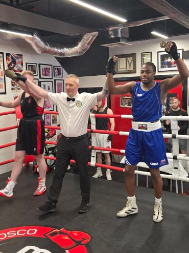 Boxer in blue declared winner in ring.