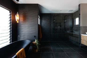 Matte black free standing bath with twin matte black shower rose. 