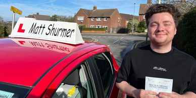 A young man from West Wickham, Bromley proudly holding his automatic driving test pass certificate.