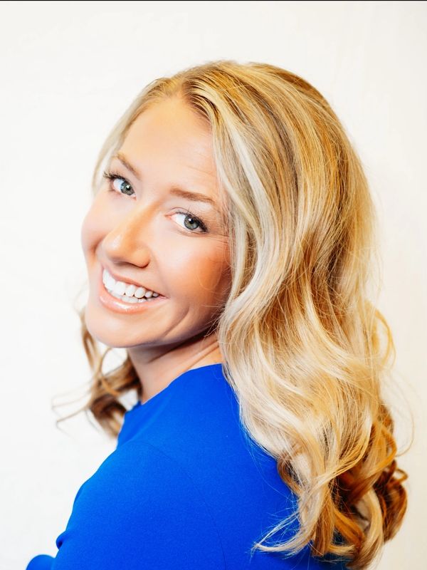 Smiling woman with blonde hair in a blue top.