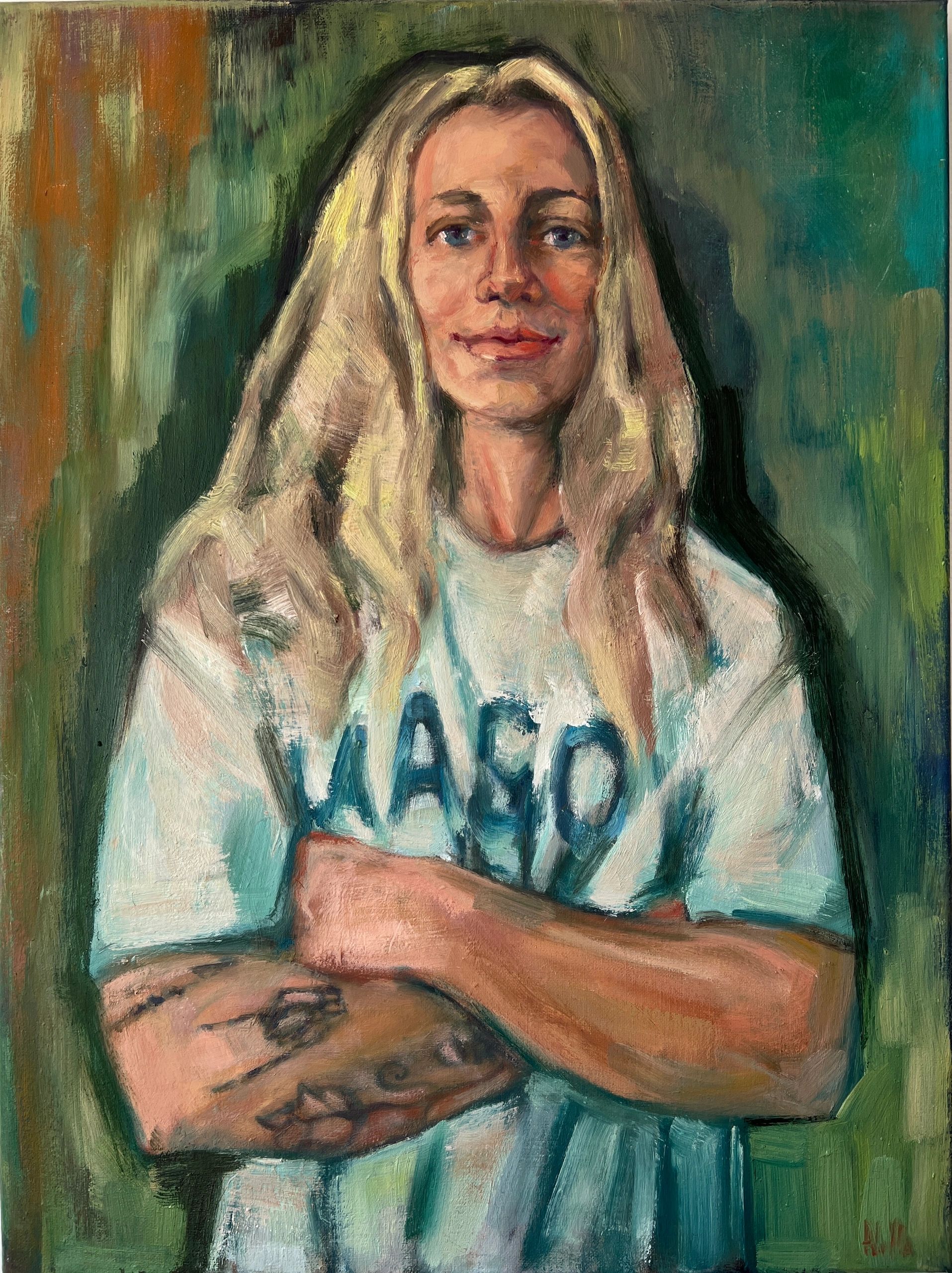 Portrait of a woman with long blonde hair wearing a white shirt with "WASO" text.