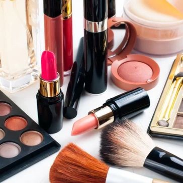 An assortment of makeup products including lipsticks, eyeshadow palettes, and brushes.