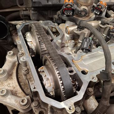 Close-up of a car engine's timing belt and camshaft gears.