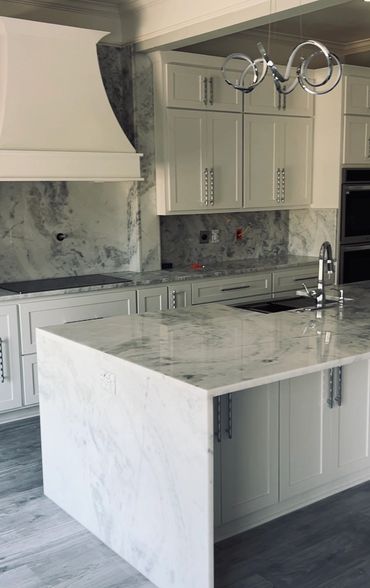 Elegant kitchen with white marble countertops and modern fixtures.