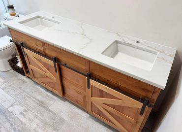 Rustic bathroom vanity with double sinks and barn-style sliding doors.