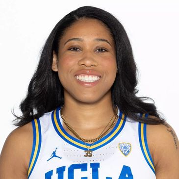 Smiling UCLA basketball player in uniform.