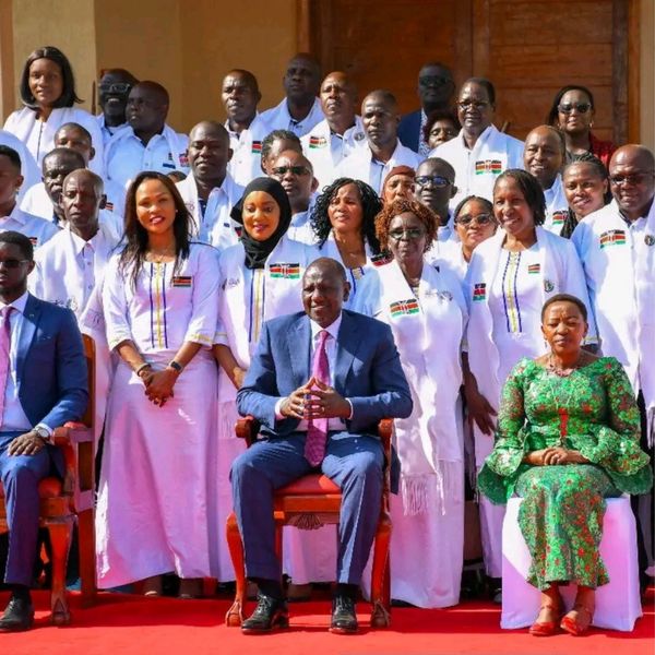 Group photo of diverse individuals in formal attire and traditional wear.