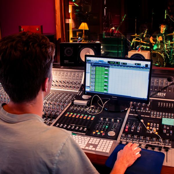 Sound engineer mixing music in a recording studio.
