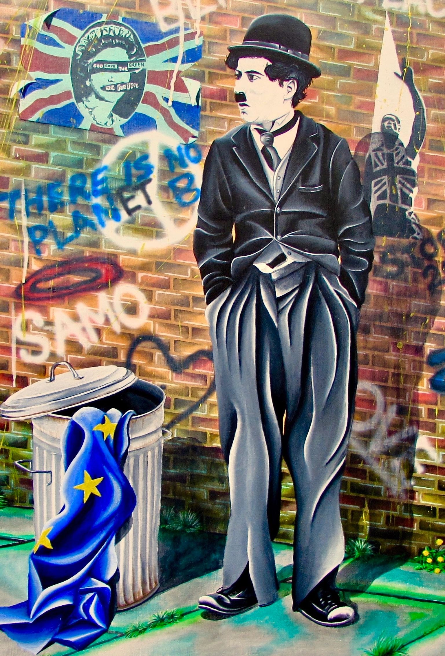 Street art featuring Charlie Chaplin beside a trash can with a European Union flag.