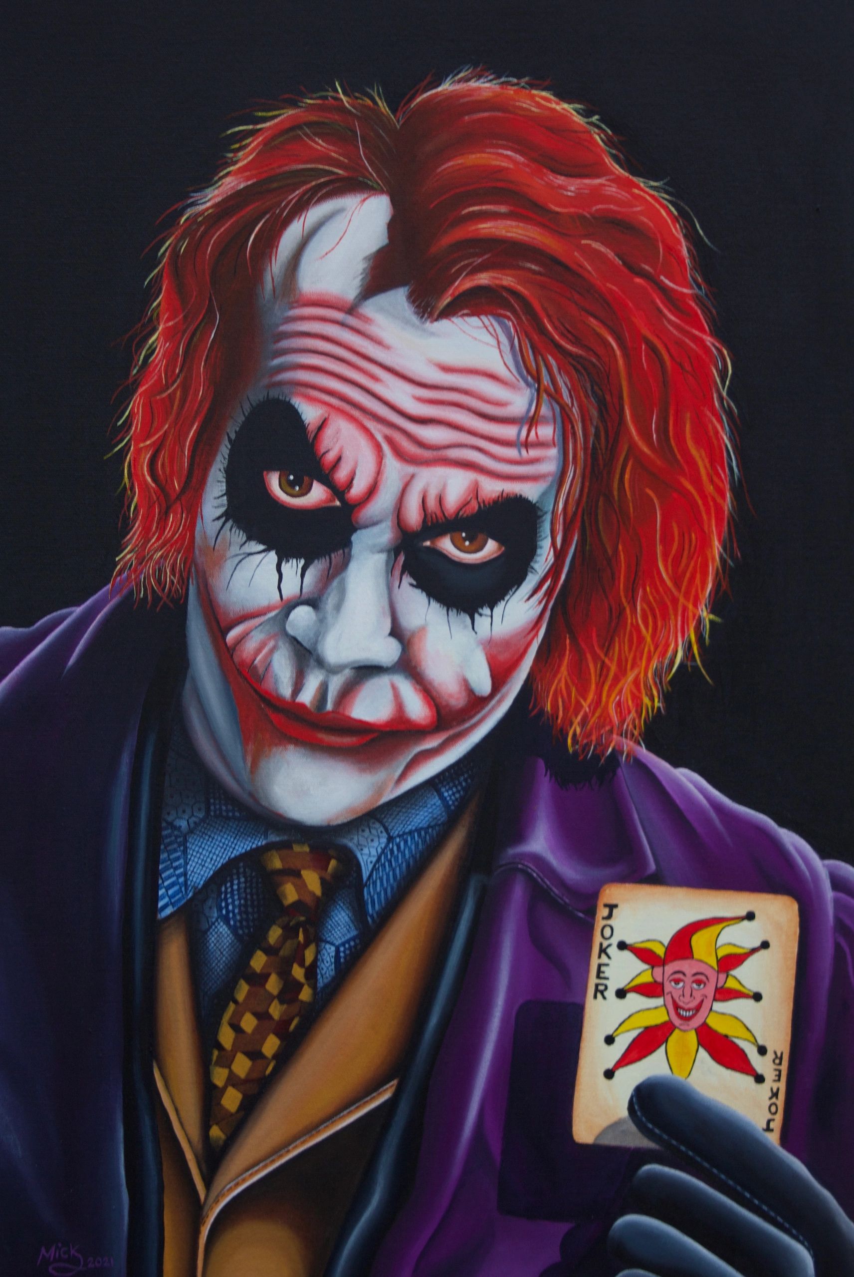 Portrait of the Joker holding a Joker card.
