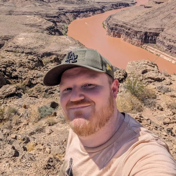 A male therapist smiling with a scenic background