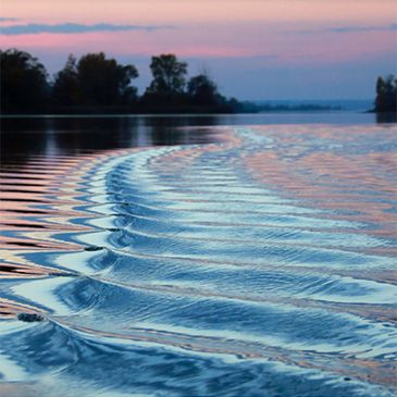 Photo of waves on a river at sunset.