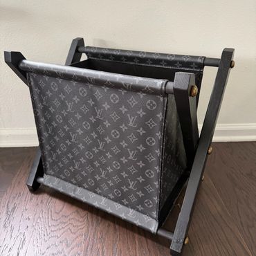 Louis Vuitton collapsible storage basket on wooden floor.