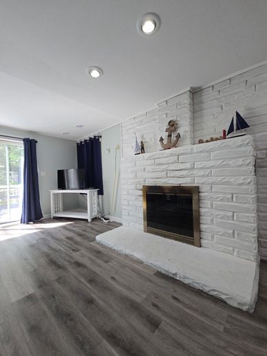 Bright living room with white brick fireplace and dark blue curtains.