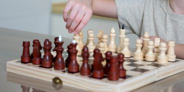 a little boy playing chess carefully 