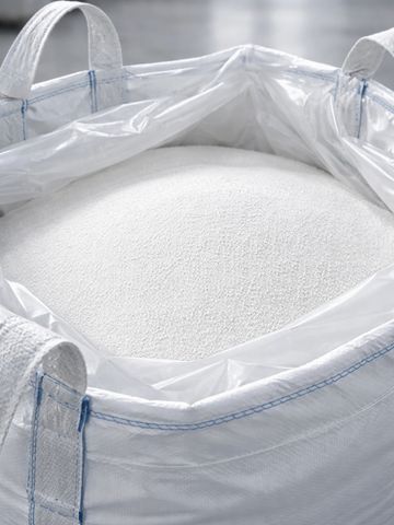 A large white industrial bag filled with small white granules.