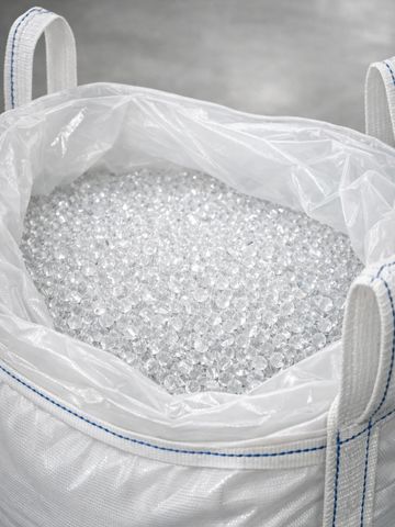 A large white bag filled with clear plastic pellets.