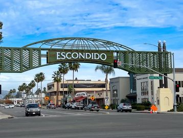 Entrance archway sign for Escondido in a busy street.