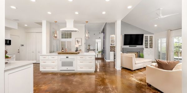 Bright modern kitchen and living room with polished concrete floors.