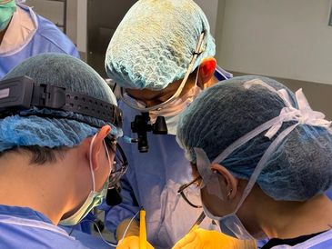 A team of surgeons performing a precise surgery in an operating room.