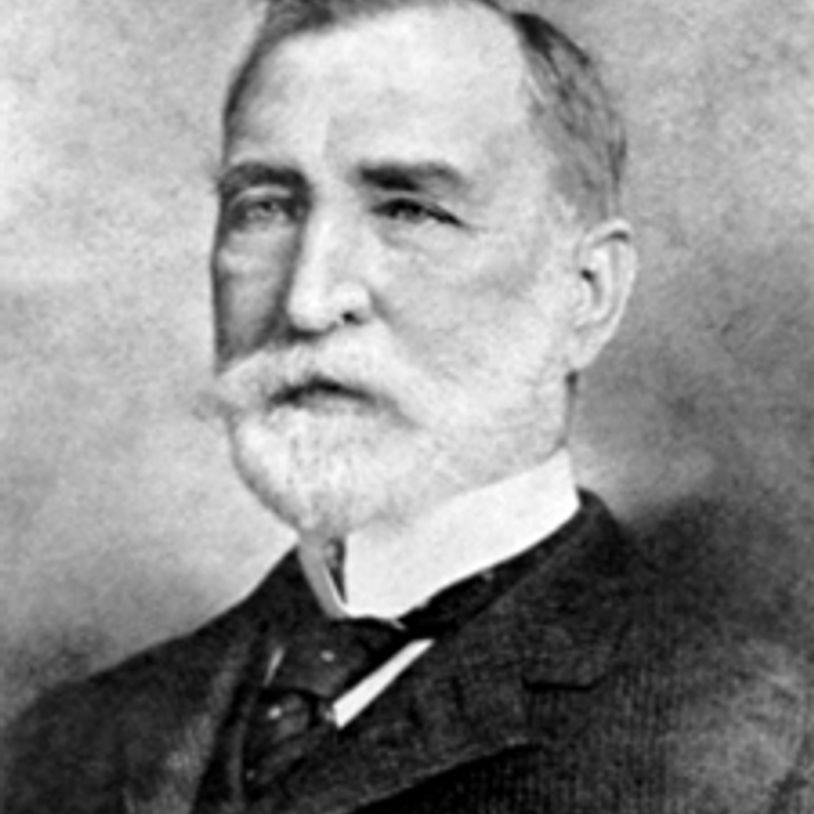 Black and white portrait of an elderly man with a beard and suit.