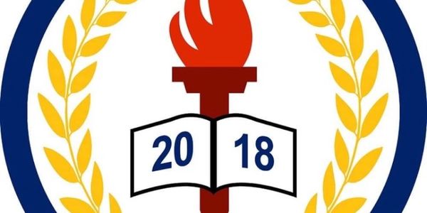 2018 emblem with torch, book, and laurel wreath.