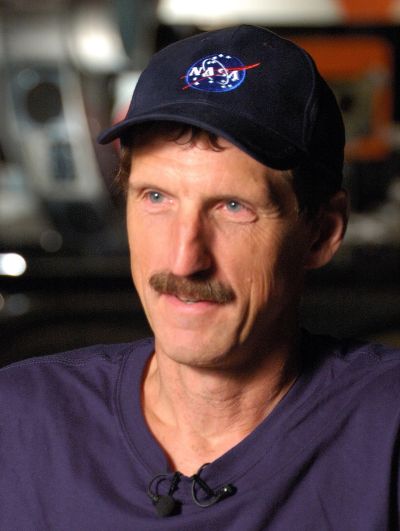 Man wearing a NASA cap with a mustache.