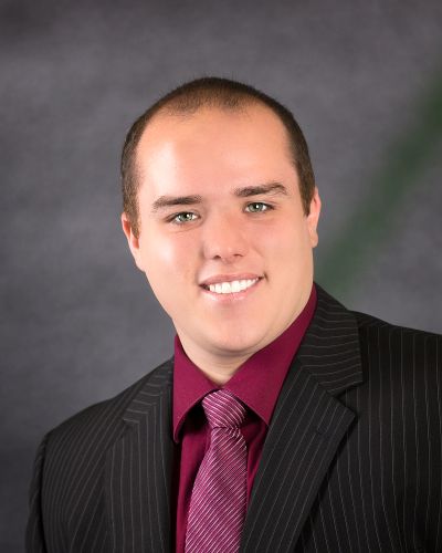 Young man in suit smiling at the camera.