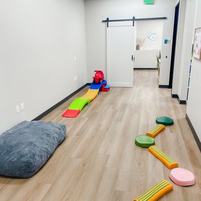 A picture of the sensory gym with a crash pad, stepping stones, and other toys. 