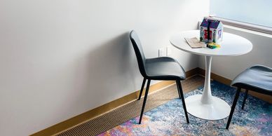 A picture of the Kidspeak Corona office. The image shows chairs and a desk with a toy house. 