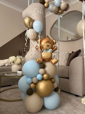 Balloon arrangement with a teddy bear and letter balloons.