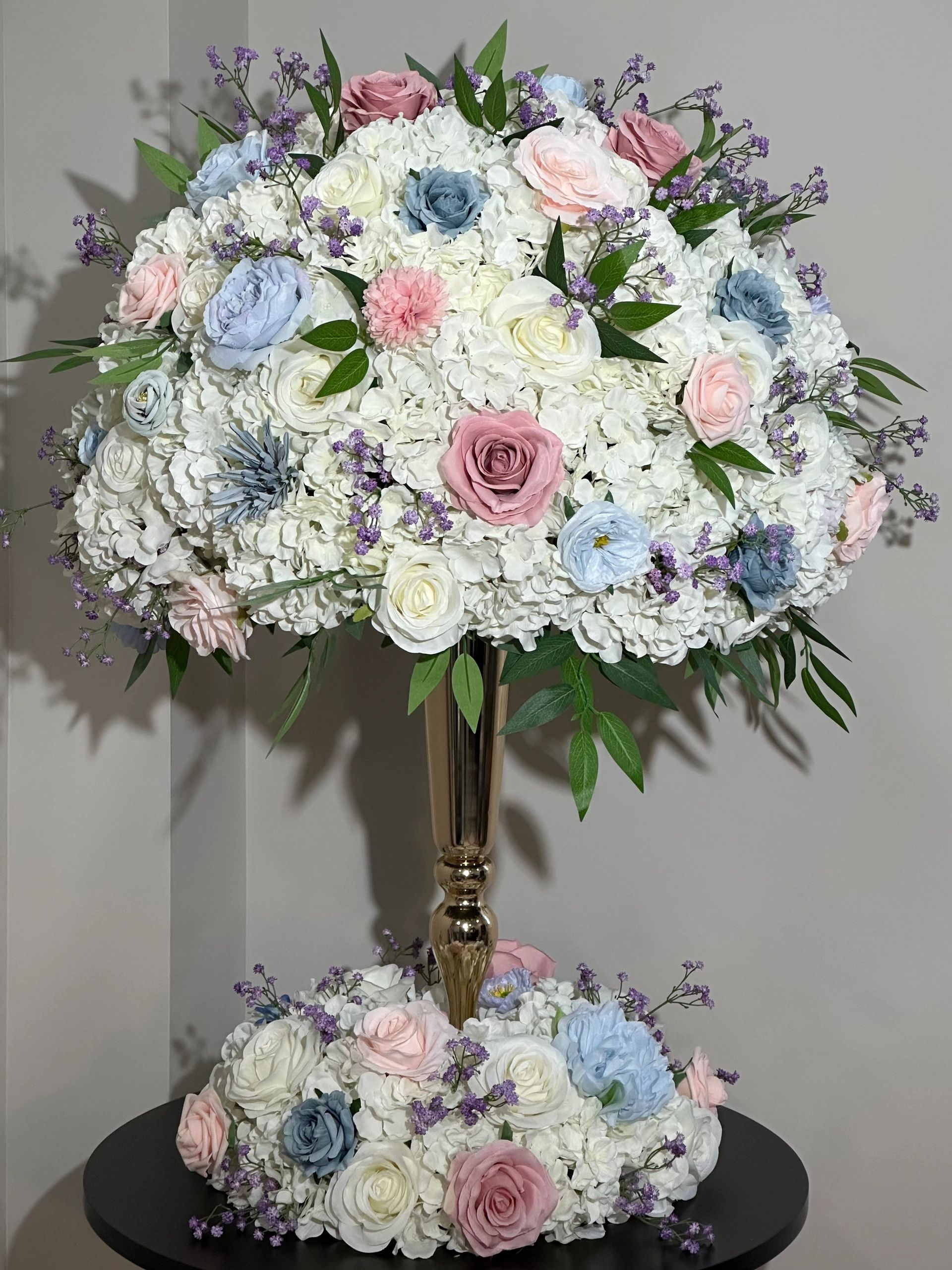 Traditional  Hydrangea arrangement with gold trumpet vase and wreath. 