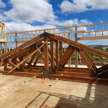 Wooden roof trusses at a construction site.